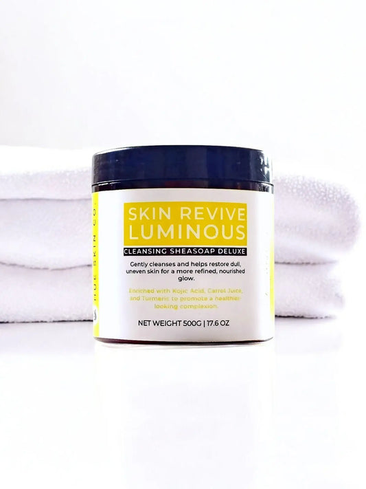 Skin Revive Luminous Sheasoap Deluxe jar placed on a white towel for skincare renewal and even tone.