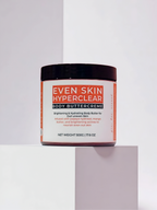 Jar of 'Even Skin Hyperclear Body Buttercreme' on a light gray background