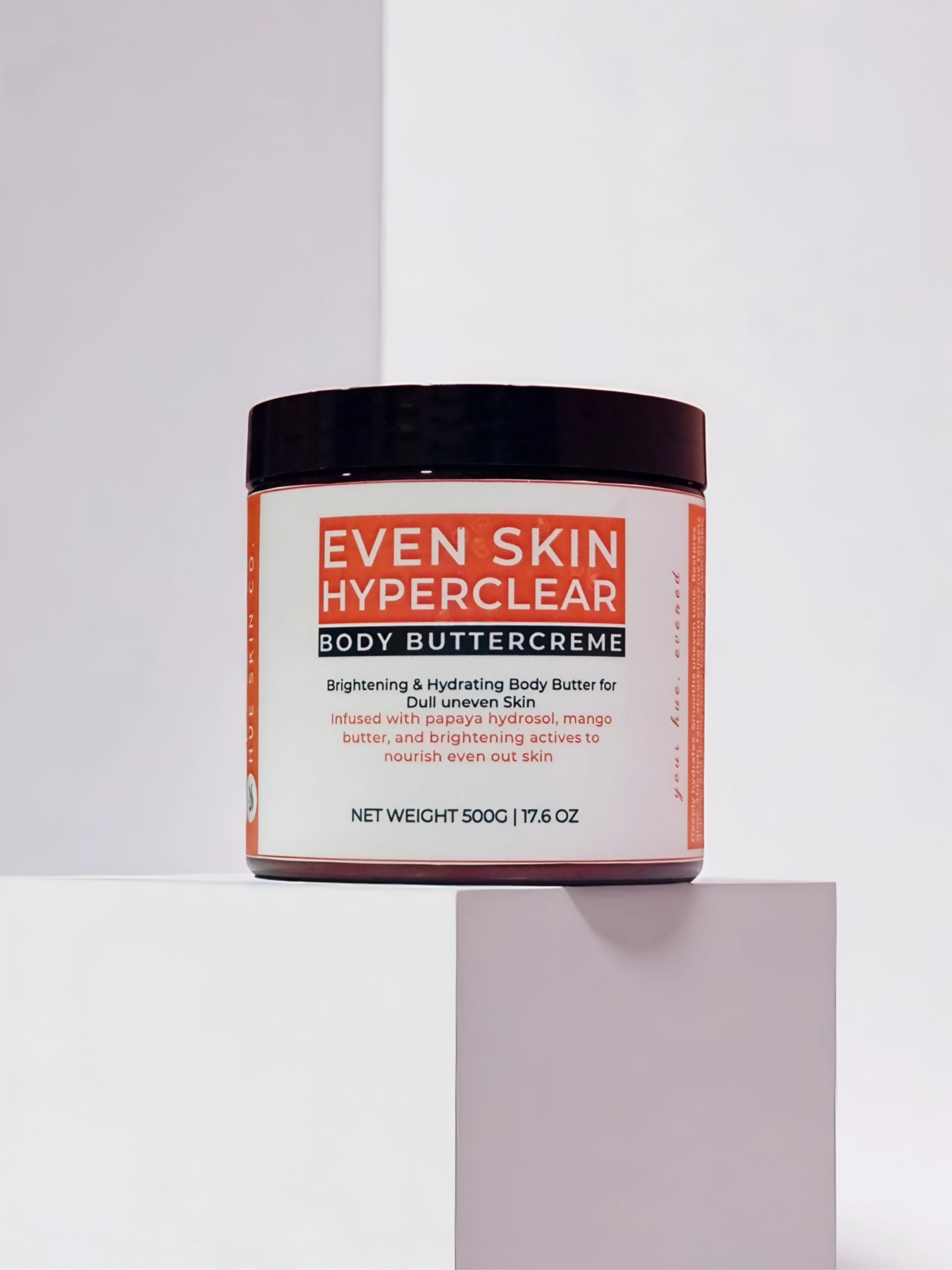 Jar of 'Even Skin Hyperclear Body Buttercreme' on a light gray background